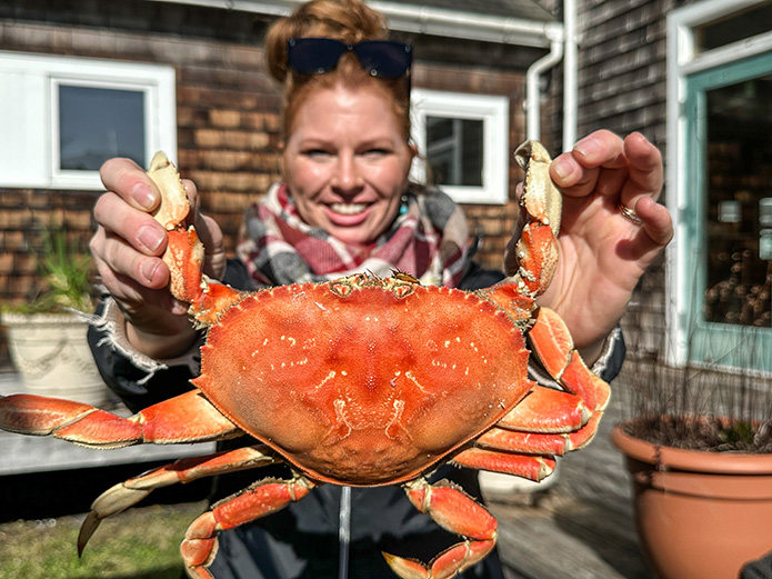 Woman holding Dungeness crab by claws